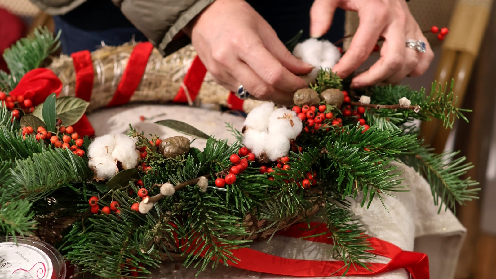 Atelier de couronnes de Noël La Lunaire chez Dodin à Biarritz — couronne de sapin, baies rouges et coton en cours de création