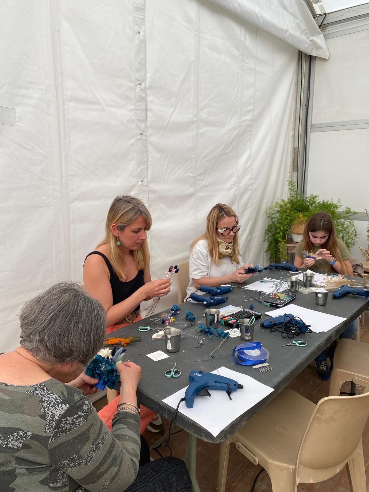 Atelier floral La Lunaire — mains d'enfant et d'adulte composant un bouquet